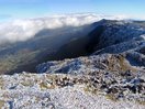 Al llegar a la cumbre, se abrió a mis pies el Valle de Araitz, muy verde, muy abajo. Más allá, persistían las nubes, sobre las que sobresalían al fondo algunas cumbres del Pirineo cubiertas de nieve.