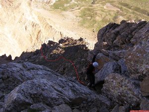 Tras descender la segunda chimenea, continuamos destrepando unos pocos metros en dirección W (ojo aquí y no descender a lo loco en dirección oeste) para destrepar hacia le derecha (en sentido de bajada) el muro ó contrafuerte que nos deja en el comienzo de la travesia horizontal y muy cerca del comienzo de la primera chimenea.
