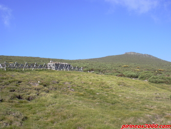 El refugio y, al fondo, la rocas cumbreras del Torozo.