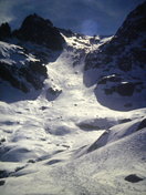 El Carquerazo con la Portilla de los Machos visto desde la puerta del refugio. La nieve está helada y se aprecia alguna cascada. En muchas ocasiones al llegar a los Barrerones hay que ponerse los crampones para bajar al Circo.