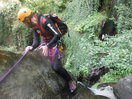 Sujeto al tercer pasamanos y a caballo sobre la roca de salida del tercer rápel.